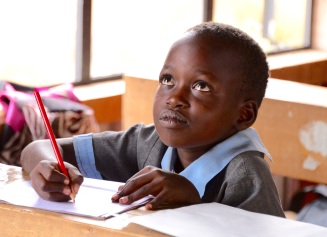 Maasai child working on a letter
